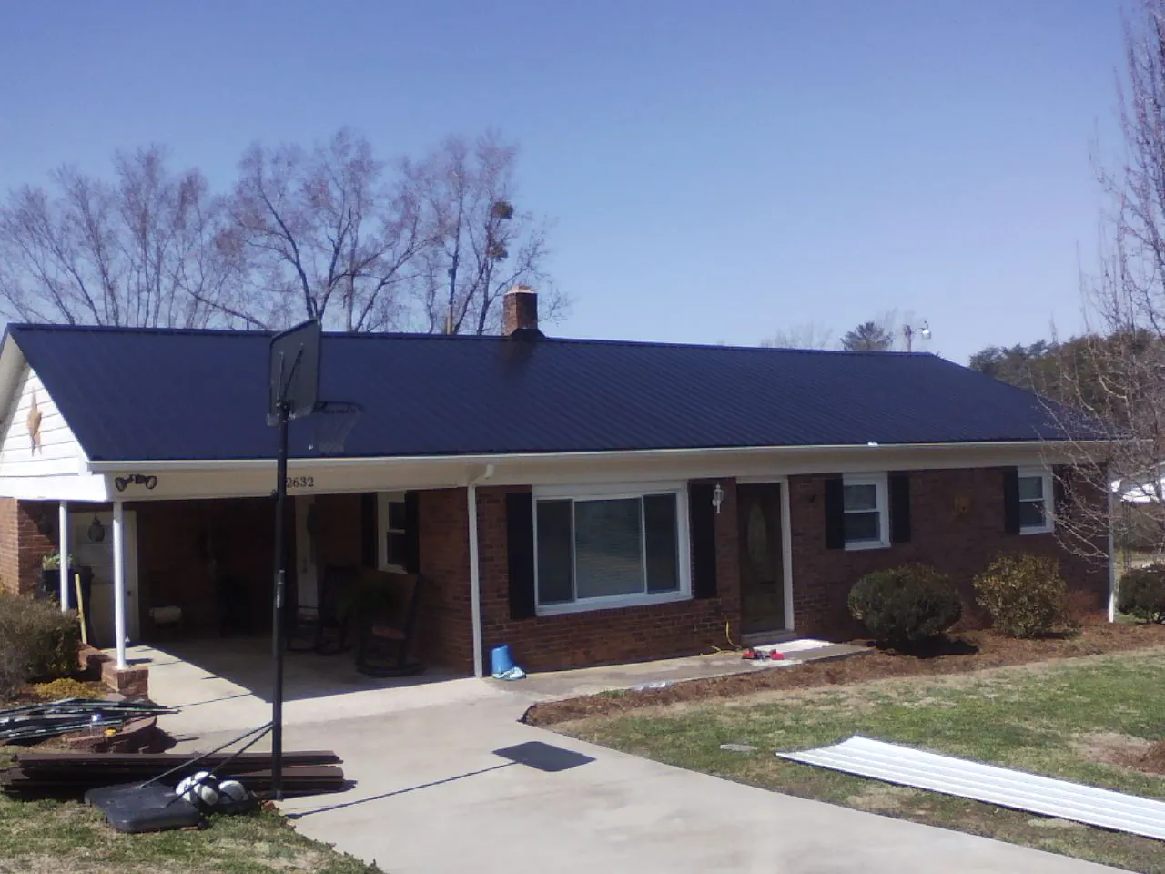 Finished dark blue metal roof on a brick ranch with a carport in Arcadia